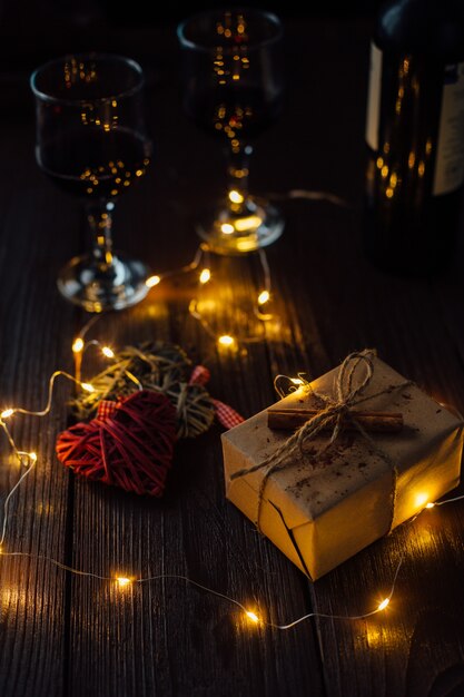 Valentine's Day. Romantic Composition of two hearts, box gift, lights and two glass of wine