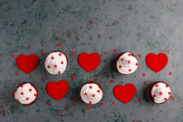 Valentines day background, chocolate cupcakes with heart shaped candies,top view