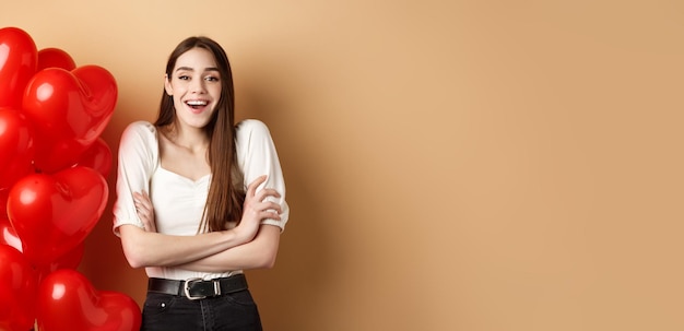 Foto gratuita concetto di giorno di san valentino bella giovane donna divertirsi ridendo e sorridendo alla macchina fotografica in piedi vicino