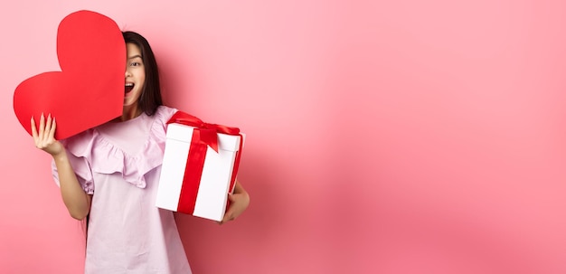 Free photo valentines day concept happy young girl asian holding romantic gifts red heart card from lover and p