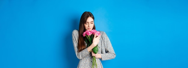 バレンタインデーのコンセプト 情熱的でロマンチックな若い女性がフロリダの匂いがするギフト バラの花束を抱き締める