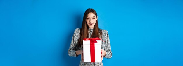 Valentines day concept surprised happy girl receiving romantic gift and looking thankful at camera s