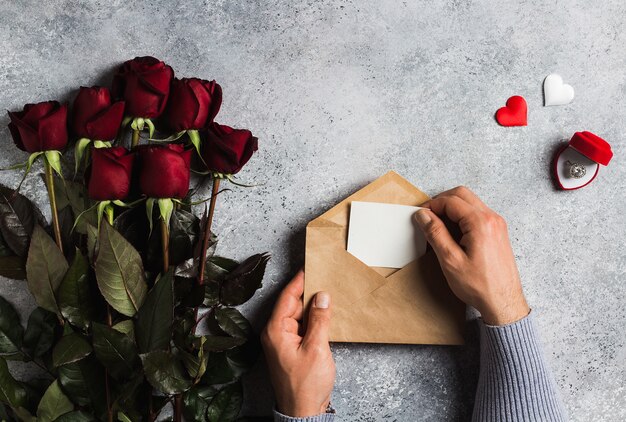 グリーティングカードと封筒ラブレターを持っているバレンタインデー男の手