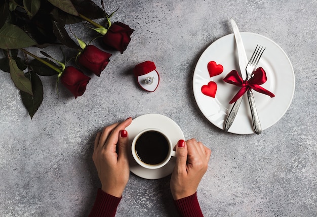 Free photo valentines day romantic dinner table setting woman hand holding cup of coffee