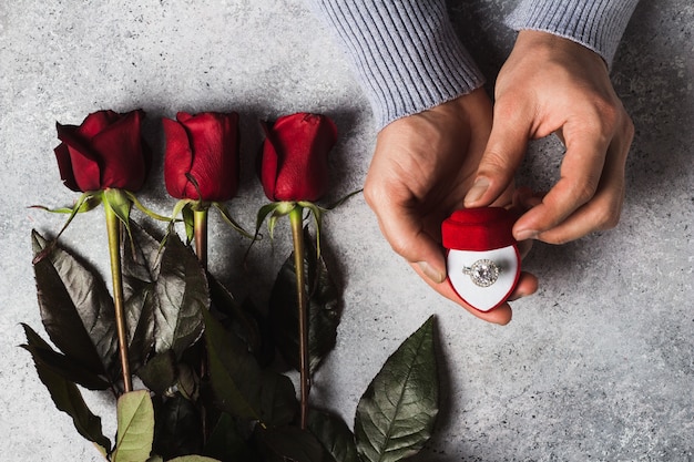 Foto gratuita anello di fidanzamento romantico della tenuta della mano dell'uomo di giorno di biglietti di s. valentino in scatola