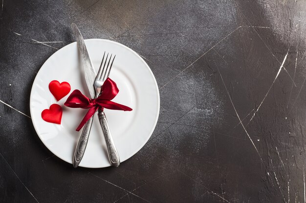 バレンタインの日のテーブルセッティングのロマンチックな夕食は私と結婚してプレートフォークナイフ