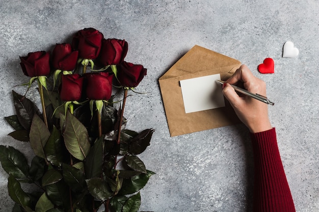 グリーティングカードとラブレターを書くペンを持つバレンタインデー女性手