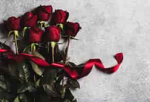 Foto gratuita la rosa rossa di giorno di madri delle donne di giorno di biglietti di s. valentino con la sorpresa del regalo del nastro