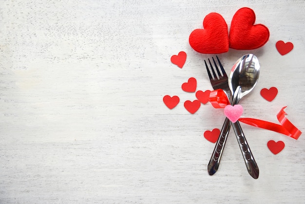 バレンタイン​ディナー​ロマンチックな​愛​の​概念​フォーク​スプーン​と​白い​木​の​赤い​ハート​で​飾られた​ロマンチックな​テーブル​セッティング