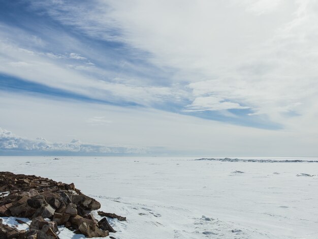 Valley covered with snow on a cold winter day under the bright cloudy sky