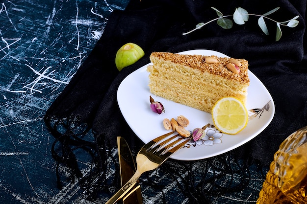 Free photo vanilla cake isolated on blue background in a white plate.