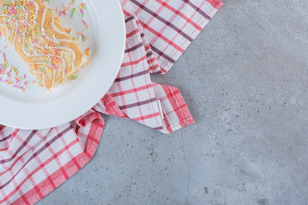 Free photo vanilla flavored sweet roll decorated with sprinkles on white plate.