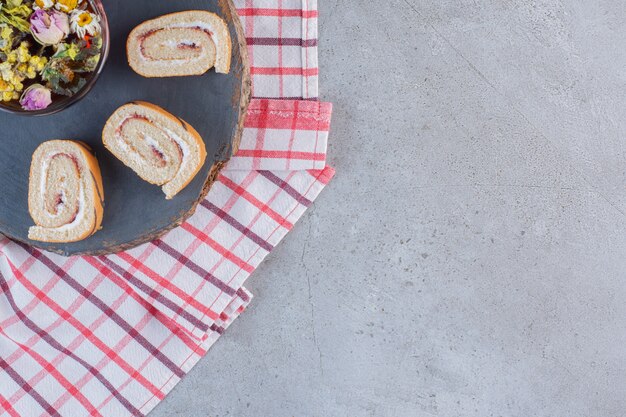 Vanilla flavored sweet rolls and cup of tea on wood piece.