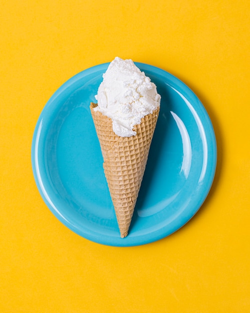 Vanilla ice cream scoop with cone on plate