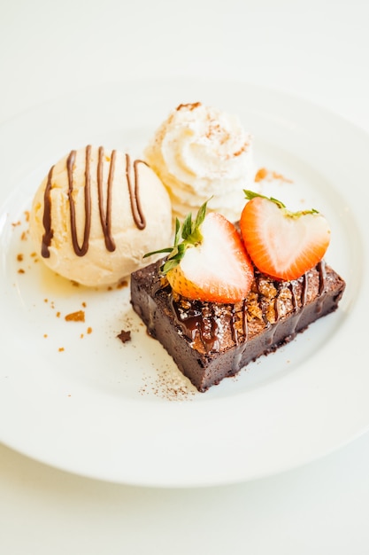 Vanilla ice cream with chocolate brownie cake with strawberry on