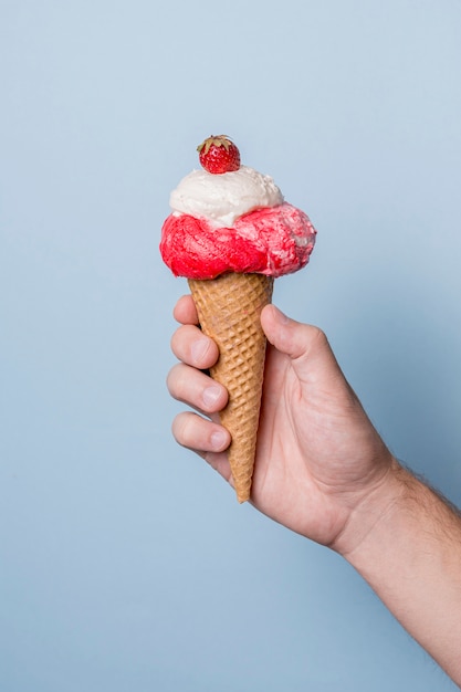 Vanilla and strawberries ice cream on cone