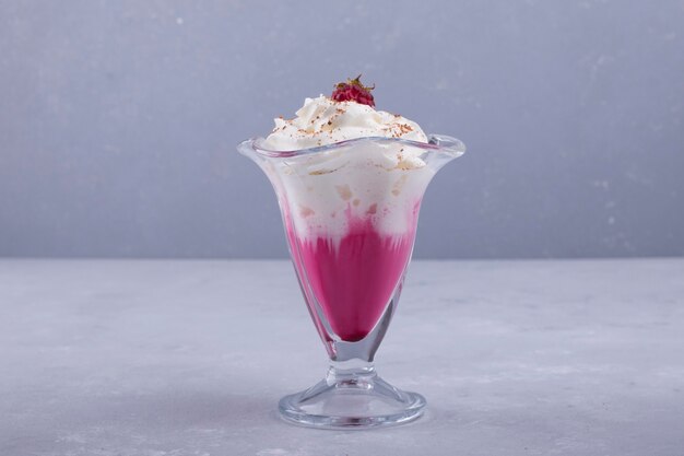 Vanilla strawberry icecream with cinnamon powder in a glass cup