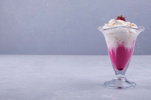 Vanilla strawberry icecream with cinnamon powder in a glass cup