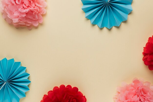 베이지 색 배경으로 배열 된 아름 다운 화려한 종이 접기 꽃의 변형 패턴