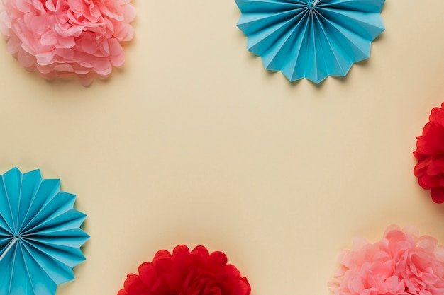 Variation pattern of beautiful colorful origami flowers arranged on beige backdrop