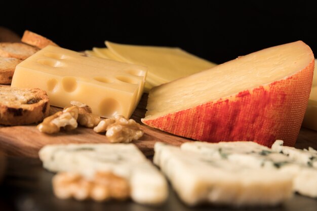 Variation of tasty cheeses on wooden table