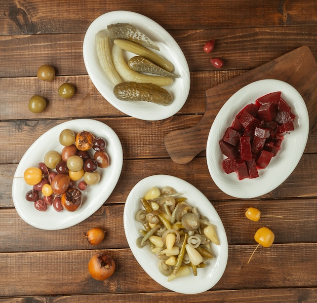 Variety of apetizers, marinated food selections in white plates