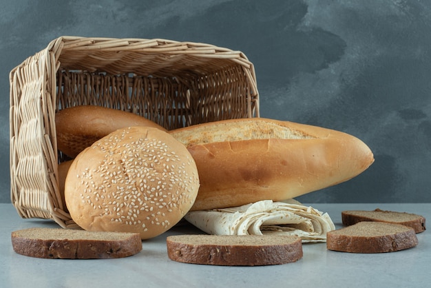 バスケットのパンと石のテーブルの小麦の様々な