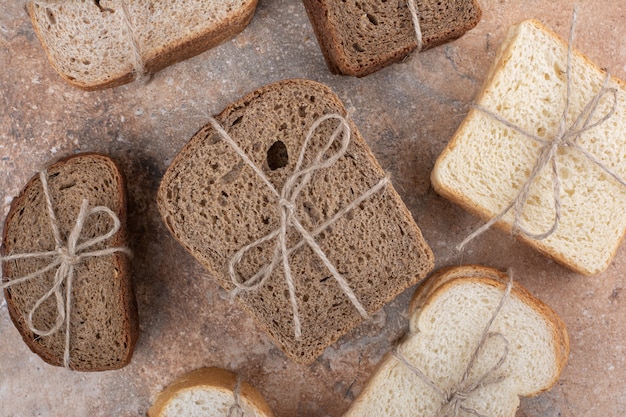 Variety of bread tied with rope on marble background