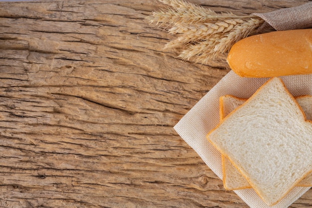 Variety of bread on wooden table on an old wooden background.