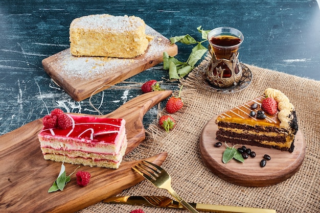 Variety of cake slices with a glass of tea. 