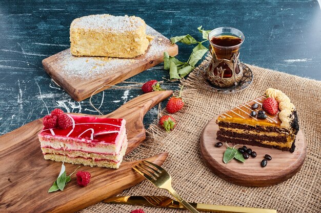 Variety of cake slices with a glass of tea. 