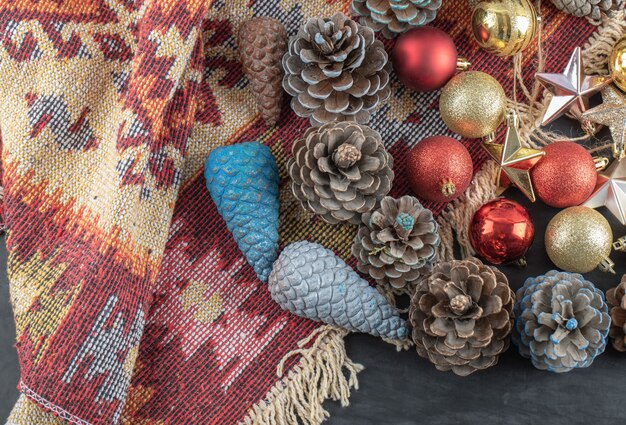 Variety of Christmas tree ornaments on a piece of red pattern ethnic rug