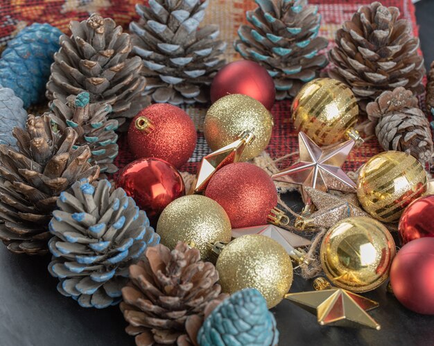 Variety of Christmas tree ornaments on a piece of red pattern ethnic rug