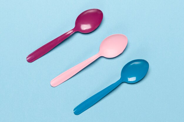 Variety of coloured spoons on blue background