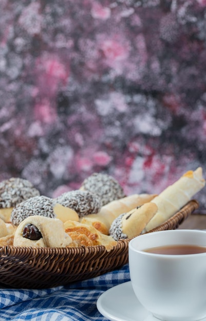 Foto gratuita varietà di biscotti nel vassoio con una tazza di tè da parte.