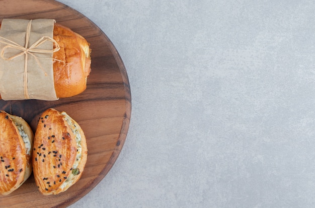 Variety of delicious pastries on wooden board.