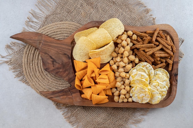 Variety of delicious snacks on wooden board. 