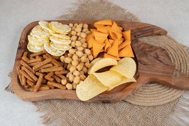 Variety of delicious snacks on wooden board