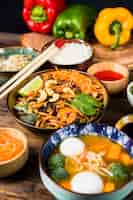 Free photo variety of delicious thai food with chopsticks on wooden table