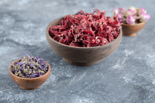 Variety of dried flowers in wooden bowls.