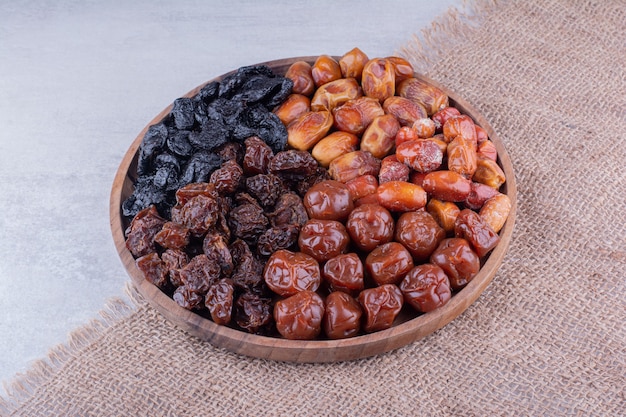 Free photo variety of dry fruits on a wooden platter