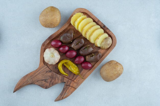 A variety of fermented vegetable on a board, on the marble.