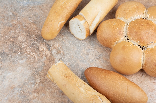 Variety of fresh bread on marble background