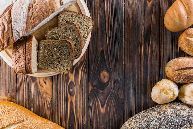 Variety of freshly baked bread on dark wooden table