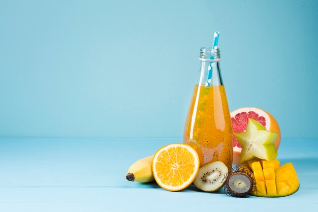 Variety of fruit and juice on blue background