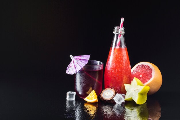 Variety of fruit and juices on black background