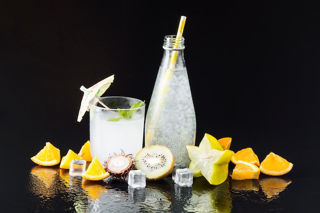 Variety of fruit and juices on black background