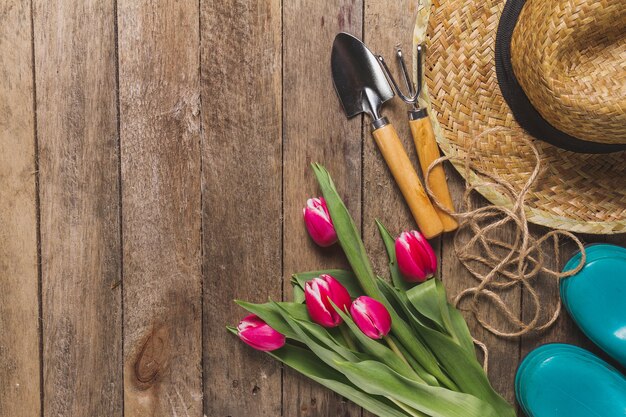 Variety of gardening tools and flowers on wooden table