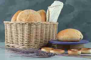 Бесплатное фото Разнообразие хлеба в корзине и крекеров на каменной поверхности