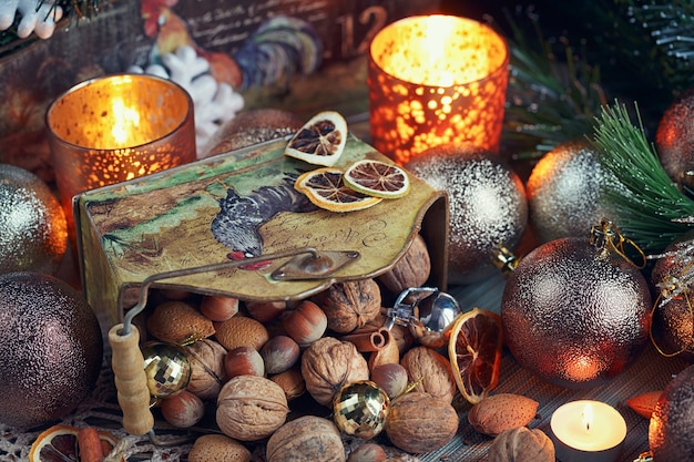 クリスマス​と​新年​の​装飾​の​ナッツ​の​様々な​。​モミ​の​木​の​枝​、​キャンドル​、​休日​が​木製​の​背景​に​照らして​クリスマス​と​新年​の​構成